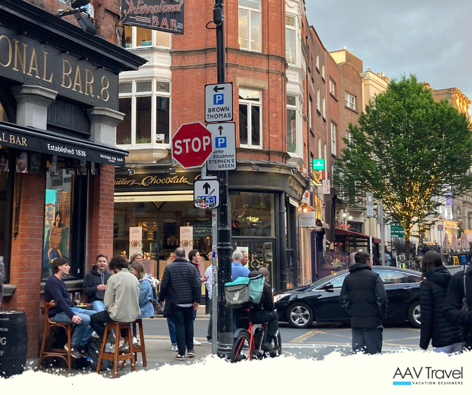 A street view of Dublin’s Wicklow Street, with the iconic International Bar in the foreground and a stretch of vibrant storefronts and pedestrians beyond.