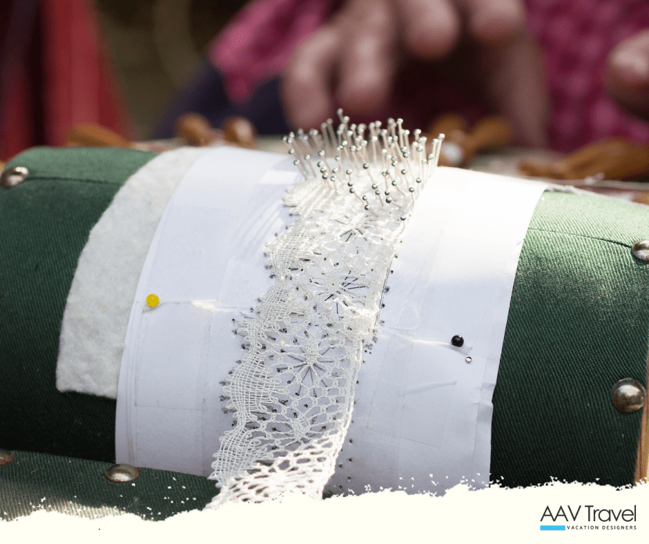 Lacemaker in Le Puy-en-Velay, France, skillfully using bobbins and threads to create intricate handmade lace patterns—an endangered French textile tradition supported by cultural tourism and artisan workshops